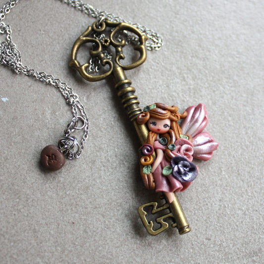 Collana in acciaio inox con chiave bronzata e fatina in fimo