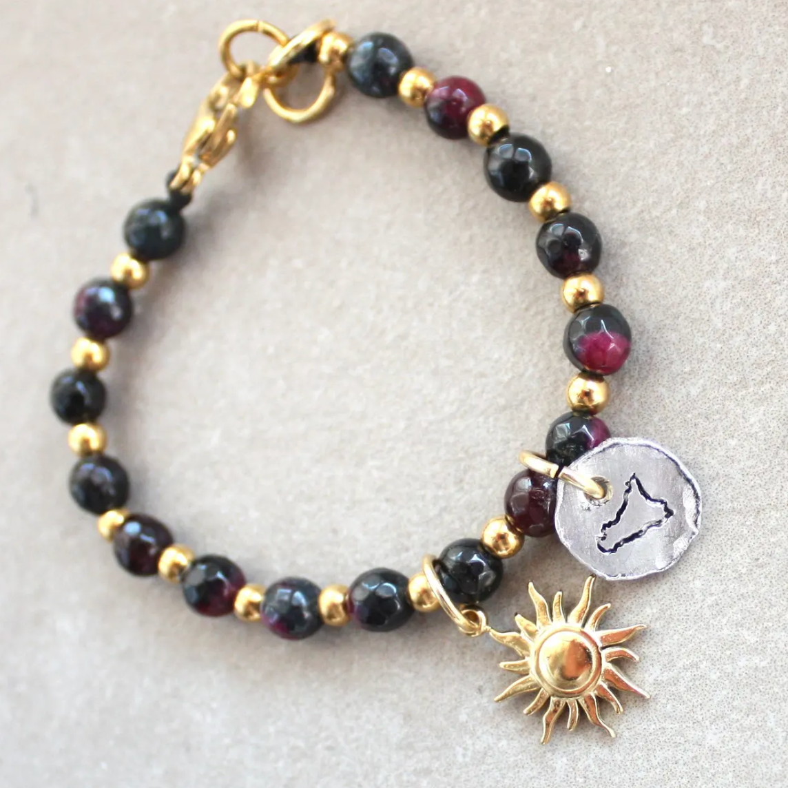 bracciale pietre dure nere e dorate con sicilia incisa a mano e sole 