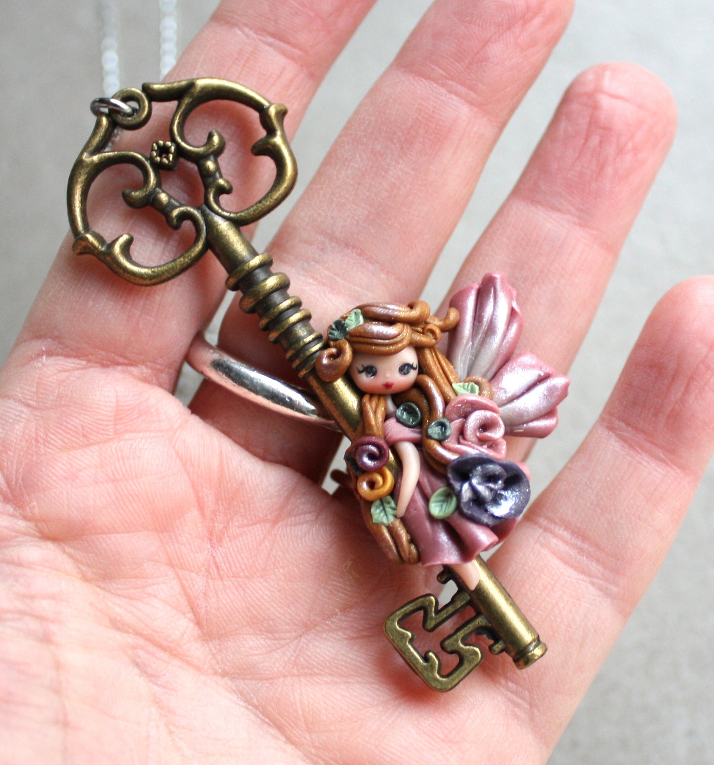 Collana in acciaio inox con chiave bronzata e fatina in fimo