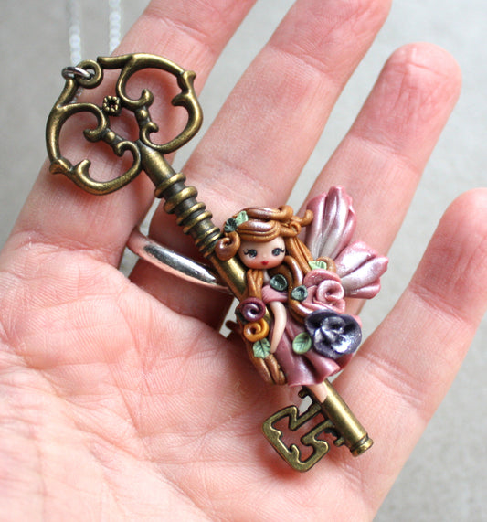 Collana in acciaio inox con chiave bronzata e fatina in fimo