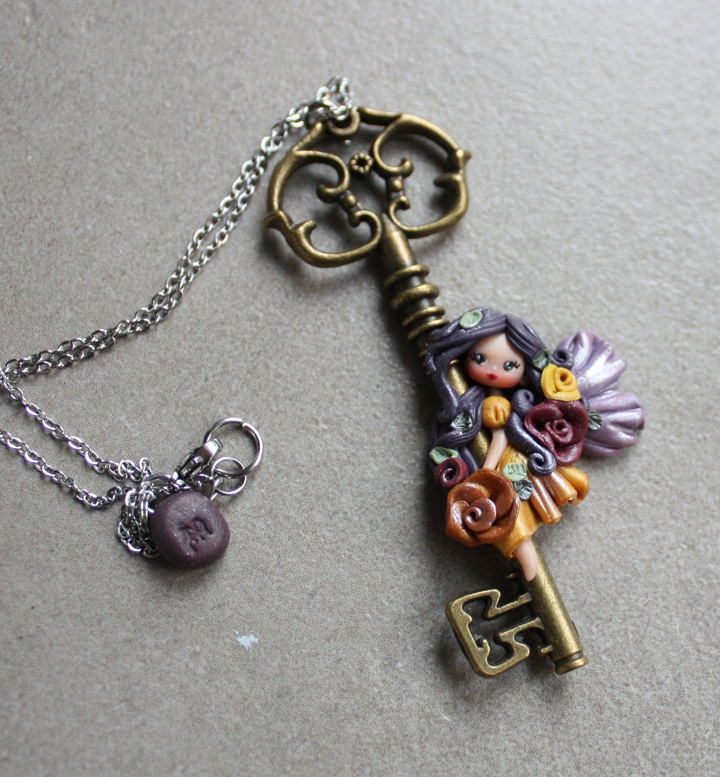 Collana in acciaio inox con chiave bronzata e fatina in fimo II