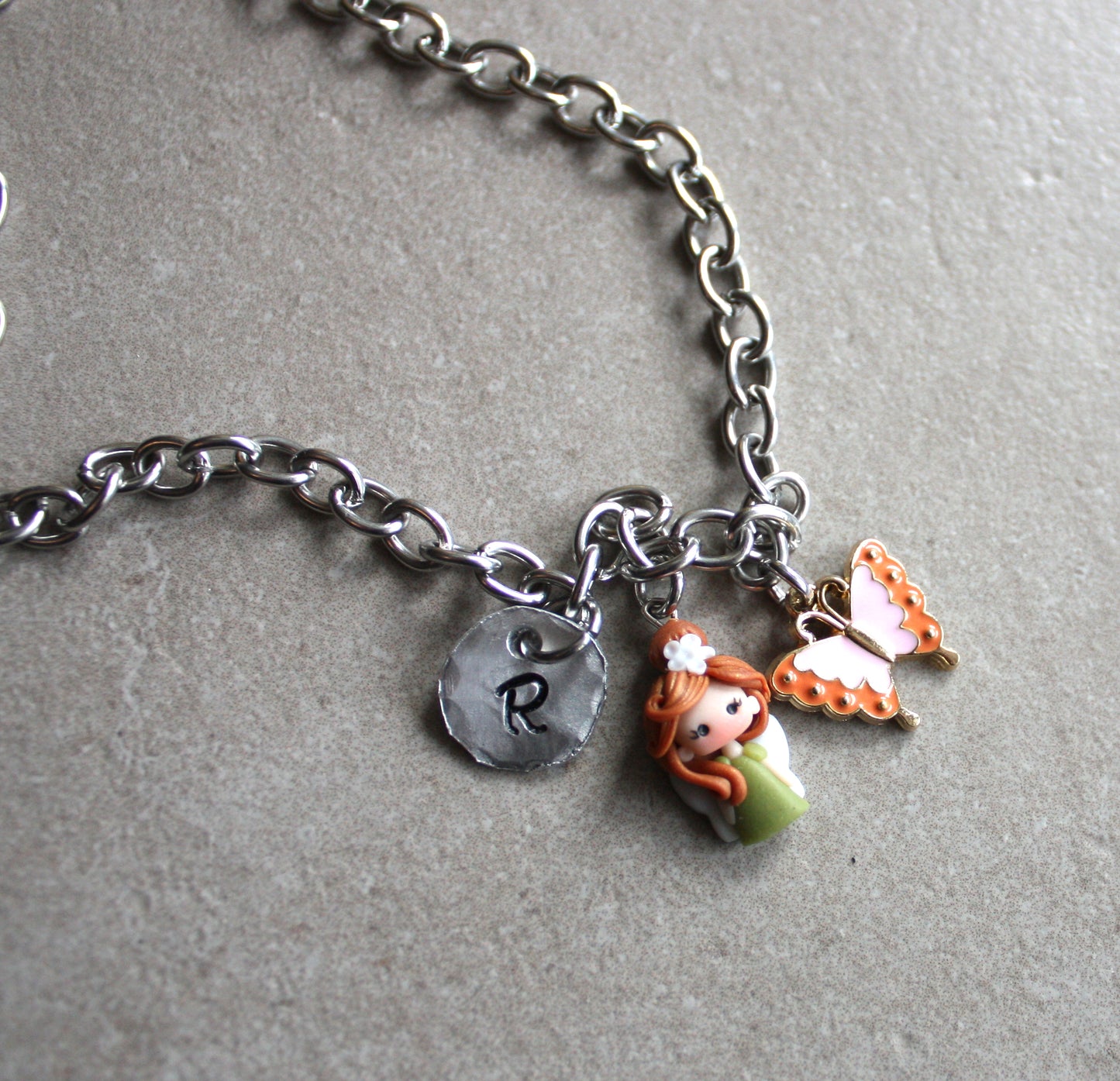 Collana  girocollo in  acciaio inox con lettera e fatina